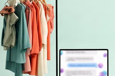 Perchero de una tienda de moda online junto a una pantalla con conversación sobre cambios de talla